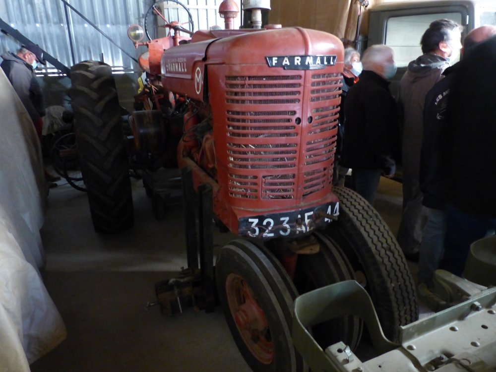 Tracteur Farmall qui sert à entrainer une batteuse avec la poulie latérale